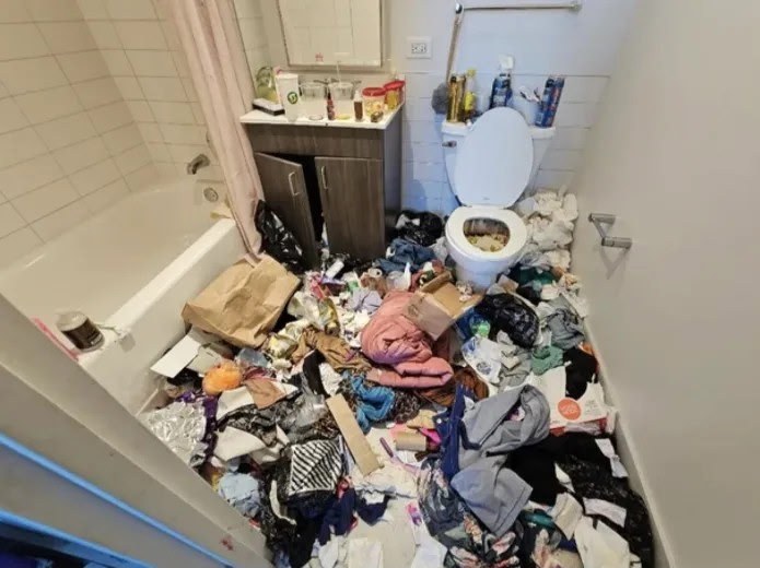 Before: bathroom floor covered in trash