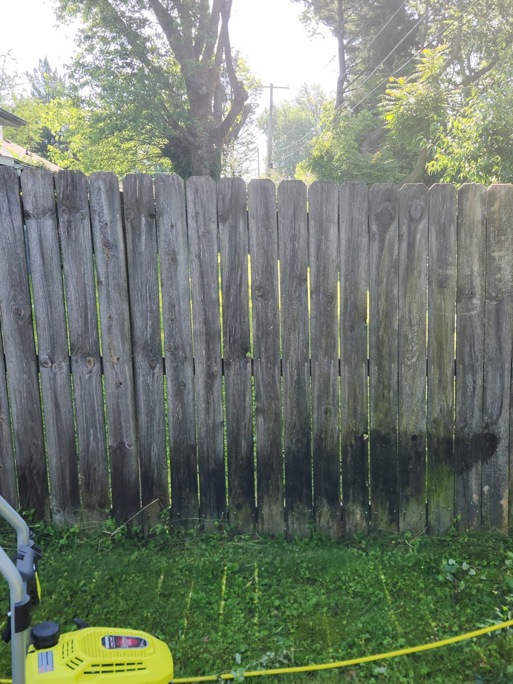 Before: weathered privacy fence